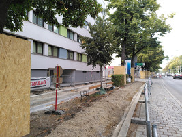 Baustelle, die Hälfte der Fußverkehrsfläche wird zu einem Radweg umgebaut, in der Grünfläche daneben stehen noch zwei Sitzbänke, die bisher direkt neben der Fußverkehrsfläche lagen und durch den im Bau befindlichen Radweg von dieser abgetrennt werden