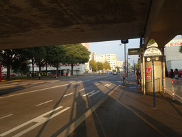Bushaltestelle unter U-Bahn-Hochtrasse, Haltestellen der Gegenrichtung auf der anderen Straßenseite liegen in deutlichem Abstand im Hintergrund